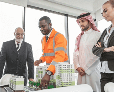 Professionals discussing a building model in an office.