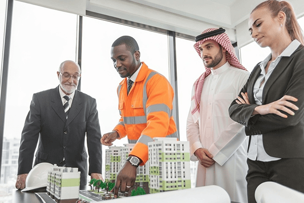 Construction Meeting With Architects Professionals discussing a building model in an office.