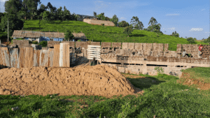 View of construction site surrounded by lush green hills.