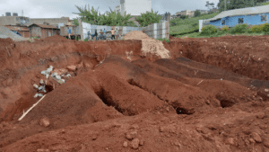Excavation site with multiple mounds of reddish dirt.