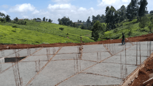 Construction site with rebar and green hills in the background.