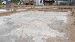 Construction site with muddy ground and water puddles.
