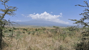 A scenic view of a mountain under a blue sky with clouds.