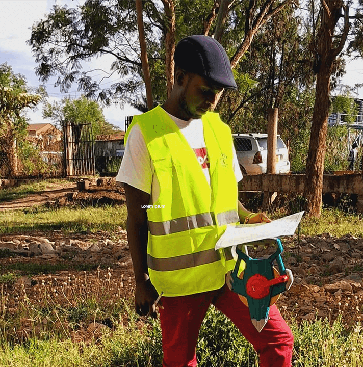 Worker In Reflective Vest With Tools A worker in a yellow reflective vest examining a plan outdoors.