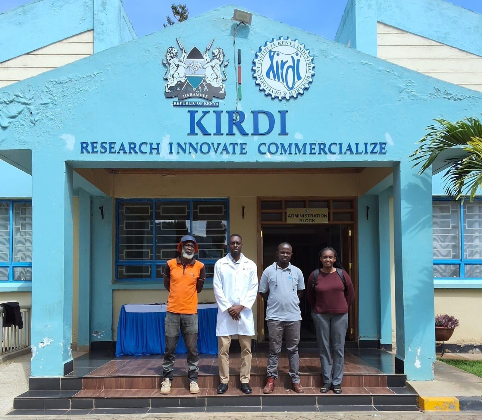 Four individuals standing before the KIRDI administration building.