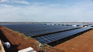 Expansive solar panel installation under a clear blue sky.