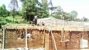 Construction site with workers building a brick structure.