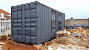 Gray shipping container home under construction.