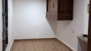 Empty room featuring a wall cabinet and brown tiled flooring.