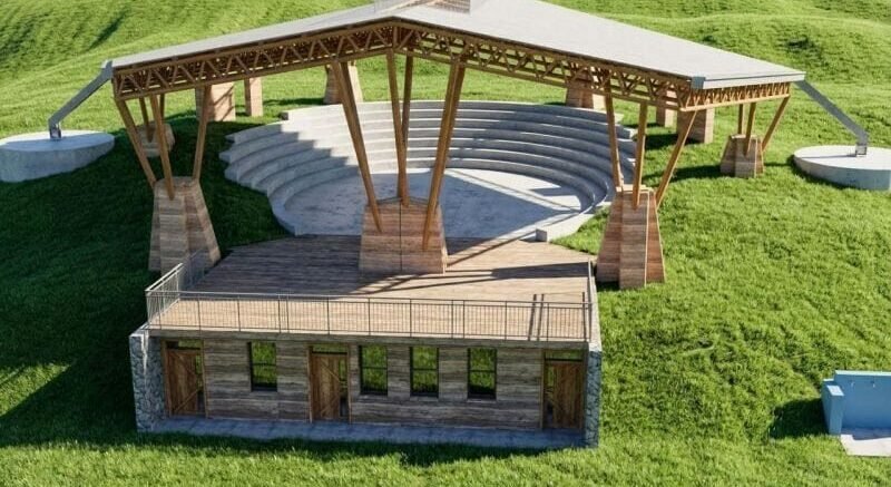 Modern Auditorium Design A modern outdoor auditorium with wooden features and grassy surroundings.