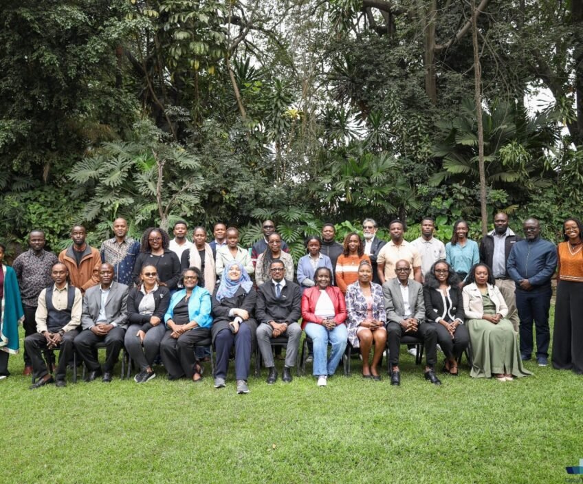 Group photo of diverse individuals in a lush green setting.