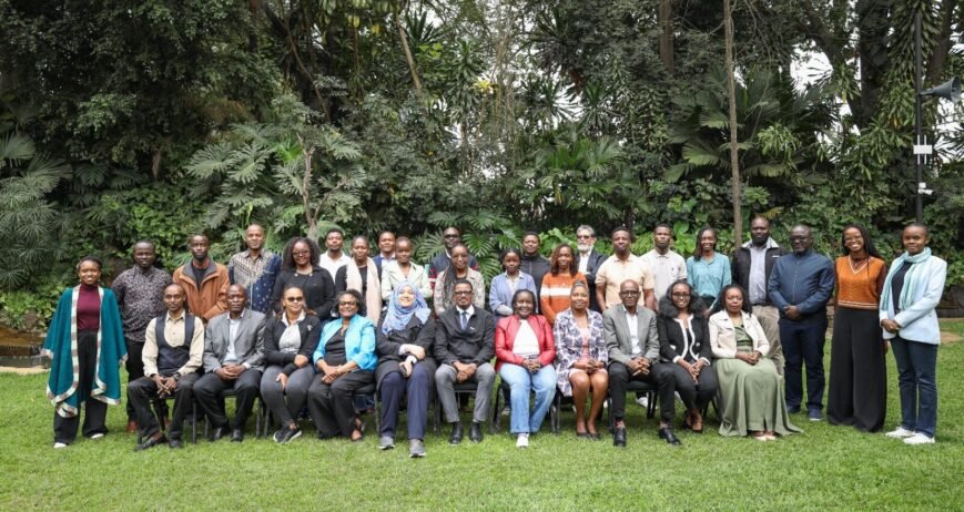 Group photo of diverse individuals in a lush green setting.