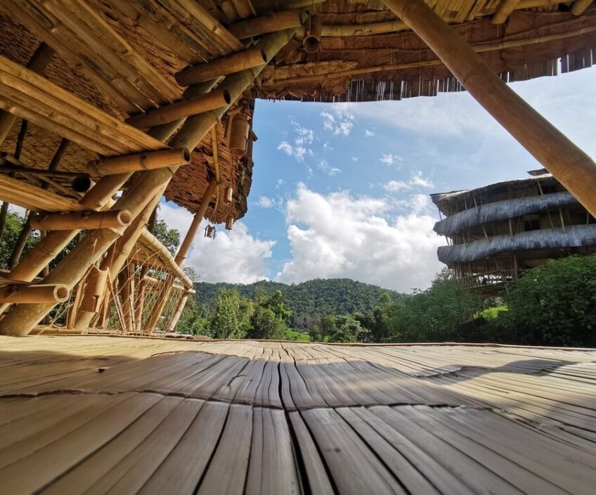 Bamboo structure with mountain view under a clear sky.