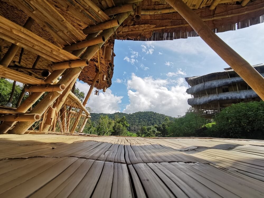 Bamboo structure with mountain view under a clear sky.